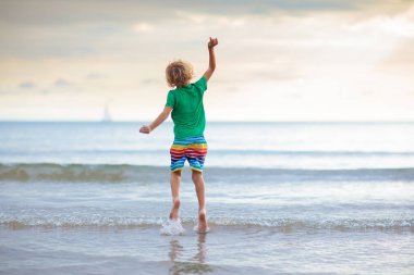 Tropik plajda oynayan bir çocuk. Deniz kıyısındaki küçük erkek bebek. Aile yaz tatili. Çocuklar su ve kum oyuncaklarıyla oynuyor. Okyanus ve ada eğlencesi. Asya 'da küçük çocuklarla seyahat et..