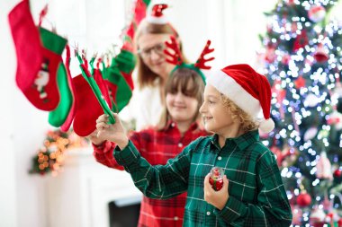 Çocuklar Noel hediyelerini açıyor. Çocuk kış sabahı çorap takviminde şeker ve hediye arıyor. Çocuklu aileler için süslenmiş Noel ağacı. Xmas eğlencesi.