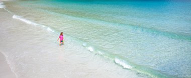 Tropik sahilde oynayan çocuk. Egzotik adadaki çocuklar. Deniz ve okyanus eğlencesi. Lüks tatil aile yaz tatili. Küçük bir çocukla seyahat edin. Çocuklar yüzer. Yüzme ve güneşkoruma giyimi.