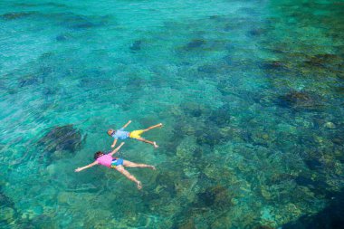 Çocuklar şnorkel. Kumsal eğlencesi Çocuklar yaz tatilinde egzotik adada tropikal denizde şnorkelle yüzüyorlar. Maskeli ve yüzgeçli çocuk. Genç bir çocukla seyahat et. Oğlan ve kız dalmayı öğreniyor. Dalış tatili.