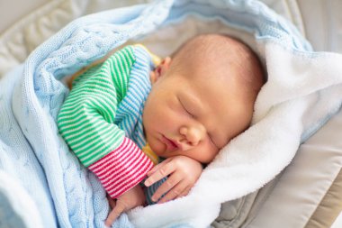 Yeni doğan bebek hastane odasında. Yeni doğan çocuk ahşap co uyuyan beşik. Başucu beşik uyku bebek. Kasa ortak bir yatak yan yatak uyku. Küçük çocuk örme battaniye altında kestiriyor.