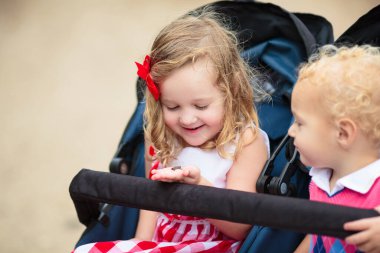 Çocuklar kurbağa yakalar. Oğlan ve kız kurbağaya bakıyor. Çocuklar ve vahşi hayvanlar. Yaz parkında yürüyüş yaparken eğlenceli bir keşif. Bebek arabasında yeni yürümeye başlayan bir çocuk. Çocuklar doğayı keşfeder ve keşfeder..