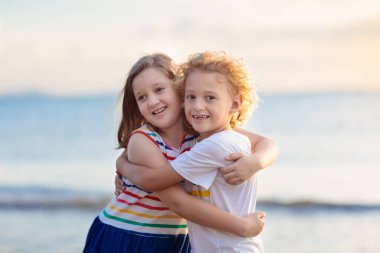 Tropik plajda oynayan bir çocuk. Deniz kıyısındaki küçük kız ve oğlan. Aile yaz tatili. Çocuklar su ve kum oyuncaklarıyla oynuyor. Okyanus ve ada eğlencesi. Asya 'da küçük çocuklarla seyahat et..