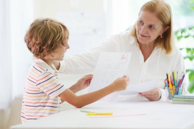 Mükemmel bir A notla okul sınavı yapan çocuk. Sınavdan sonra öğrenci mutlu. Elinde not kağıdı olan küçük bir çocuk. Okul harcı ve ev ödevi okuldaki en iyi notlar için yardımcı olur.