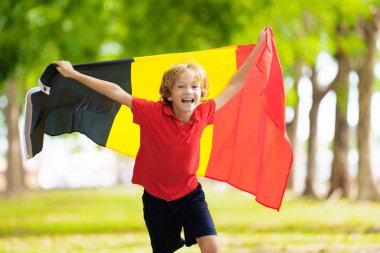 Belçika futbol fanatiği. Ulusal bayrağı olan Belçikalı bir çocuk. Zaferi kutlamak için tezahürat yapan küçük çocuk. Bastır Kırmızı Şeytanlar! Çocuklar futbol maçında gol attılar. Jersey 'li küçük çocuk açık havada sahada..
