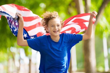4 Temmuz kutlu olsun. Ulusal bayrak taşıyan ABD taraftarı. Bağımsızlık Günü 'nü kutlayan mutlu çocuk. Amerikan hayranı. Amerikan taraftarları futbol sahasında takımın maçını izliyorlar. Heyecanlı çocuk Amerika için tezahürat yapıyor.. 