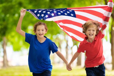 4 Temmuz kutlu olsun. Ulusal bayrak taşıyan ABD taraftarı. Bağımsızlık Günü 'nü kutlayan mutlu çocuk. Amerikan hayranı. Amerikan taraftarları futbol sahasında takımın maçını izliyorlar. Heyecanlı çocuk Amerika için tezahürat yapıyor.. 