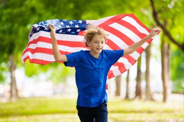 4 Temmuz kutlu olsun. Ulusal bayrak taşıyan ABD taraftarı. Bağımsızlık Günü 'nü kutlayan mutlu çocuk. Amerikan hayranı. Amerikan taraftarları futbol sahasında takımın maçını izliyorlar. Heyecanlı çocuk Amerika için tezahürat yapıyor.. 