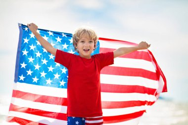 Çocuklar güneşli plajlarda Amerikan bayrağıyla koşuyor. 4 Temmuz kutlamaları. Bağımsızlık Günü 'nde Amerikan aile eğlencesi. Vatansever çocuklar Amerikan bayramını kutluyor. Amerika sembollü kız ve erkek..