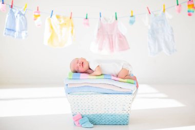 Yeni doğan bebek temiz kuru havlu yığını üzerinde. Bir havlu banyoda sonra yeni doğan çocuk. Aile çamaşır giyim. Çocuklar bir çizgi üzerinde asılı giymek. Bebek Giyim ve Tekstil çocuklar için. Duş sonra boy gülümseyerek. 