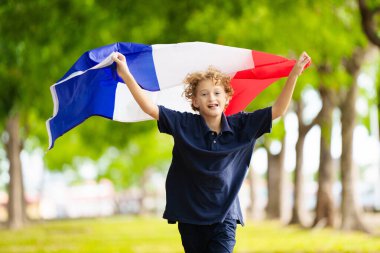 Fransız bayrağı taşıyan bir çocuk. Çocuk Fransa için tezahürat yapıyor. Ulusal bayrağı olan Fransız spor taraftarı. Bastille Günün kutlu olsun. Fransa futbolunun zaferini kutlayan heyecanlı çocuk.