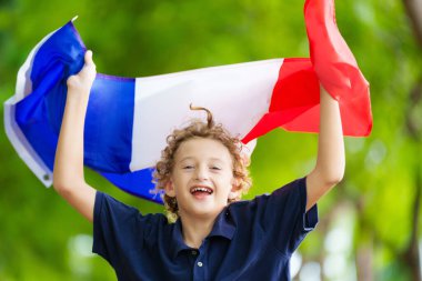 Fransız bayrağı taşıyan bir çocuk. Çocuk Fransa için tezahürat yapıyor. Ulusal bayrağı olan Fransız spor taraftarı. Bastille Günün kutlu olsun. Fransa futbolunun zaferini kutlayan heyecanlı çocuk.