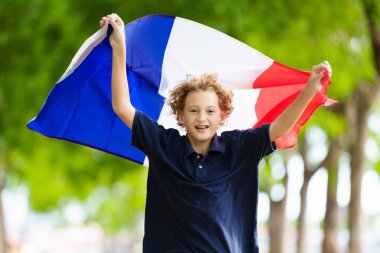 Fransız bayrağı taşıyan bir çocuk. Çocuk Fransa için tezahürat yapıyor. Ulusal bayrağı olan Fransız spor taraftarı. Bastille Günün kutlu olsun. Fransa futbolunun zaferini kutlayan heyecanlı çocuk.