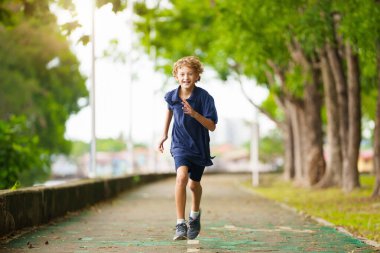 Çocuklar yaz parkında koşar. Aktif çocuk koşusu. Çocuklar için spor. Okul atletizm yarışması. Çocuklar için sağlıklı açık hava aktivitesi.
