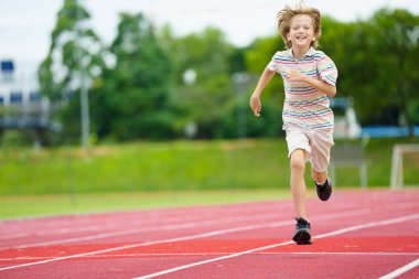 Stadyumda koşan çocuk. Spor kulübünde spor yapan bir çocuk. Yarışta genç bir sporcu. Çocuklar için sağlıklı bir açık hava sporu. Çocuklar koşar.