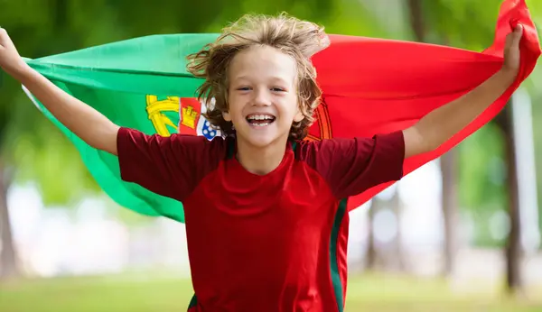 stock image Portugal football supporter kid on stadium. Portuguese soccer fan boy. Happy child with national flag and jersey cheering for Portugal. Championship game support.
