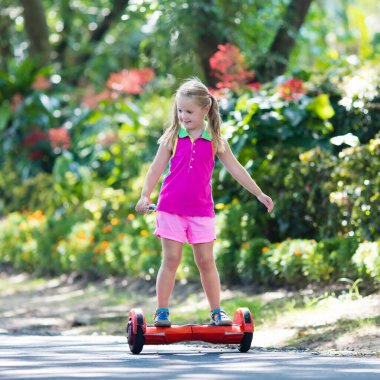 Vurgulu kurulu çocuk. Çocuklar yaz Park sürme. Çocuklar için denge kurulu. Elektrik kendini şehir sokak motorla Dengeleme. Kız Hoverboard binmek için öğrenme. Okul çocuk için modern araçlar.