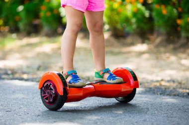 Vurgulu kurulu çocuk. Çocuklar yaz Park sürme. Çocuklar için denge kurulu. Elektrik kendini şehir sokak motorla Dengeleme. Kız Hoverboard binmek için öğrenme. Okul çocuk için modern araçlar.