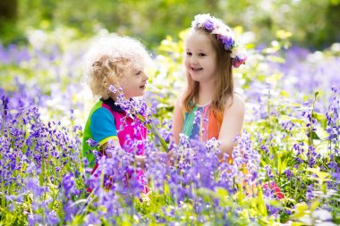 Bluebell çiçek, Bahçe aletleri ve el arabası çocuklarla. Erkek ve kız Bahçe. Çocuk bluebells, iş, bitki ve su blue Bell'de Çiçeklik açık oyun. Yaz ormandaki aile eğlence.