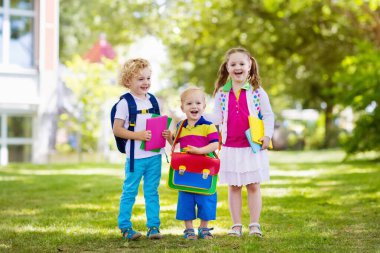 Çocuklar okula geri döner. Yaz tatilinden sonraki yıl yeni bir okula başlıyorum. İlk okul gününde sırt çantası ve kitapları olan kız ve erkek. Dersin başında. Anaokulu ve anaokulu çocukları için eğitim.