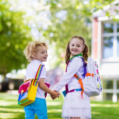Çocuklar okula geri döner. Yaz tatilinden sonraki yıl yeni bir okula başlıyorum. İlk okul gününde sırt çantası ve kitapları olan kız ve erkek. Dersin başında. Anaokulu ve anaokulu çocukları için eğitim.