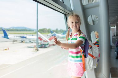 Havaalanındaki çocuklar. Çocuklar uçağa bakın. Çocukla seyahat ve uçmak. Aile çıkış kapısında. Tatil ve küçük çocukla seyahat. Uçuştan önceki çocuk. Çocuklar uçak uçurur..