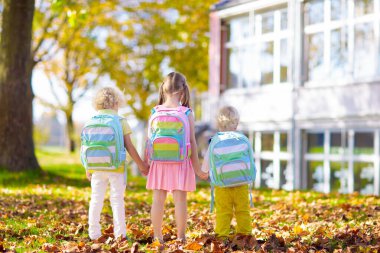 Çocuklar okula geri döner. Yaz tatilinden sonraki yıl yeni bir okula başlıyorum. İlk okul gününde sırt çantası ve kitapları olan kız ve erkek. Dersin başında. Anaokulu ve anaokulu çocukları için eğitim.