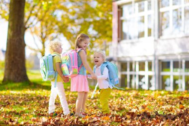 Çocuklar okula geri döner. Yaz tatilinden sonraki yıl yeni bir okula başlıyorum. İlk okul gününde sırt çantası ve kitapları olan kız ve erkek. Dersin başında. Anaokulu ve anaokulu çocukları için eğitim.