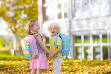 Çocuklar okula geri döner. Yaz tatilinden sonraki yıl yeni bir okula başlıyorum. İlk okul gününde sırt çantası ve kitapları olan kız ve erkek. Dersin başında. Anaokulu ve anaokulu çocukları için eğitim.