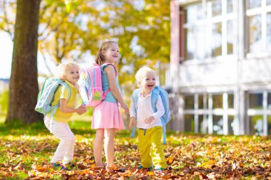 Çocuklar okula geri döner. Yaz tatilinden sonraki yıl yeni bir okula başlıyorum. İlk okul gününde sırt çantası ve kitapları olan kız ve erkek. Dersin başında. Anaokulu ve anaokulu çocukları için eğitim.