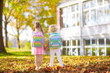 Çocuklar okula geri döner. Yaz tatilinden sonraki yıl yeni bir okula başlıyorum. İlk okul gününde sırt çantası ve kitapları olan kız ve erkek. Dersin başında. Anaokulu ve anaokulu çocukları için eğitim.