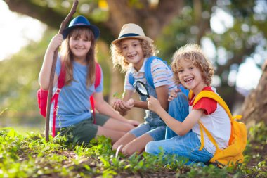 Çocuklar doğayı keşfeder. Çocuklar güneşli yaz parkında yürüyüş yaparlar. İzci kulübü ve açık hava bilimi dersi. Erkek ve kız büyüteçle bitkileri izliyor. Çocuk çevreyi keşfediyor. Genç kaşif macerası.