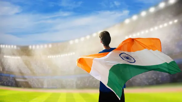 stock image India sport supporter on stadium. Indian fans on cricket, rugby or football pitch watching team play. Group of supporters with flag and national jersey cheering for India. Championship game.