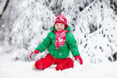 Küçük çocuk kızakla gezintiye çıkıyor. Çocuk kayağı. Kızak süren küçük bir çocuk. Çocuklar karda dışarıda oynarlar. Çocuklar kışın Alp dağlarında kızak kullanırdı. Aile Noel tatili için açık hava eğlencesi.