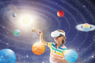 Sanal gerçeklik gözlüklü çocuk güneş sistemi modeline bakıyor. VR setinde uzayı ve evreni keşfeden çocuk. Modern çalışma cihazı. Küçük çocuk gezegenlere ve yıldızlara bakıyor. Astronomi ve fen dersi.