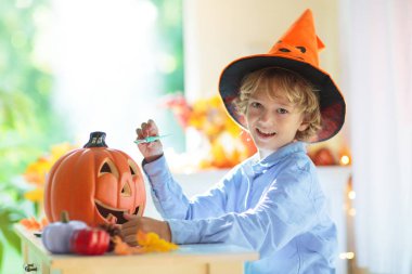 Cadılar Bayramı için aile dekorasyonu evi. Çocuklar için cadılar bayramı sanatı ve el sanatları. Şeker mi şaka mı dekorasyonu mu? Çocuklar evi dekore eder. Cadı kostümlü ve şapkalı çocuklar. Ürkütücü Cadılar Bayramı eğlencesi.