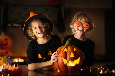 Cadılar Bayramı için aile dekorasyonu evi. Çocuklar için cadılar bayramı sanatı ve el sanatları. Şeker mi şaka mı dekorasyonu mu? Çocuklar evi dekore eder. Cadı kostümlü ve şapkalı çocuklar. Ürkütücü Cadılar Bayramı eğlencesi.