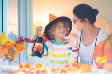 Cadılar Bayramı için aile dekorasyonu evi. Çocuklar için cadılar bayramı sanatı ve el sanatları. Şeker mi şaka mı dekorasyonu mu? Çocuklar evi dekore eder. Cadı kostümlü ve şapkalı çocuklar. Ürkütücü Cadılar Bayramı eğlencesi.