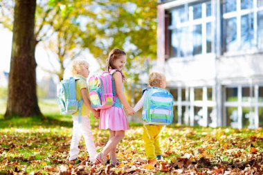 Çocuklar okula geri döner. Yaz tatilinden sonraki yıl yeni bir okula başlıyorum. İlk okul gününde sırt çantası ve kitapları olan kız ve erkek. Dersin başında. Anaokulu ve anaokulu çocukları için eğitim.