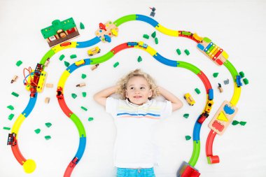 Çocuklar oyuncak tren yolu ile oynarlar. Çocuk renkli gökkuşağı ahşap trenleriyle oynuyor. Küçük çocuk için oyuncaklar. Anaokulunda ya da anaokulunda demiryolu inşaatı yapan anaokulunda. Anaokulu eğitim oyunları.