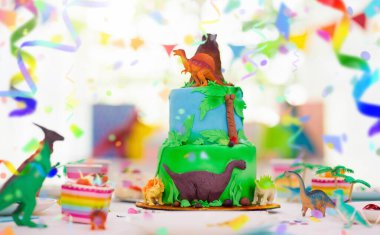 Kids birthday party. Dinosaur theme layer cake. Children event. Decoration for dinosaurs themed celebration. clipart