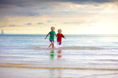 Tropik plajda oynayan bir çocuk. Deniz kıyısındaki küçük erkek bebek. Aile yaz tatili. Çocuklar su ve kum oyuncaklarıyla oynuyor. Okyanus ve ada eğlencesi. Asya 'da küçük çocuklarla seyahat et..