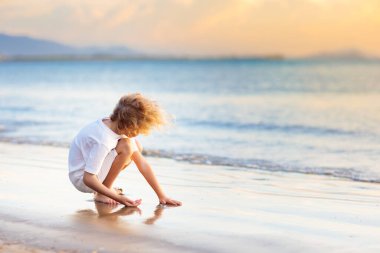 Tropik plajda oynayan bir çocuk. Deniz kıyısındaki küçük çocuk. Aile yaz tatili. Çocuklar su ve kum oyuncaklarıyla oynuyor. Okyanus ve ada eğlencesi. Asya 'da küçük çocuklarla seyahat et..