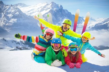 Aile kış dağlarında. Kayak ve kar tatili eğlencesi. Kayak ve snowboard yapan bir grup arkadaş. İsviçre Alplerinde kayak ve snowboard. Ebeveynler ve çocuklar için aktif ve güvenli bir spor. Yokuştaki çocuklar.