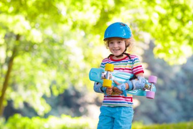 Çocuk yaz Park kaykay sürme. Küçük çocuk paten kurulu binmek için öğrenme. Etkin açık spor Okulu ve anaokulu çocukları için. Çocuk kaykay. Okul öncesi longboard üzerinde. Çocuk buz pateni.