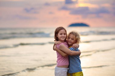 Okyanus sahilinde oynayan bir çocuk. Gün batımında dalgalara atlayan bir çocuk. Aile için deniz tatili. Küçük oğlan ve kız yaz tatilinde egzotik adada koşuyorlar. Arkadaşlık ve sevgi. Kardeşler sarılır, el ele tutuşur.
