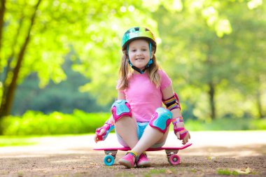 Çocuk yaz Park kaykay sürme. Küçük kız paten kurulu binmek için öğrenme. Etkin açık spor Okulu ve anaokulu çocukları için. Çocuk kaykay. Okul öncesi longboard üzerinde. Çocuk buz pateni.