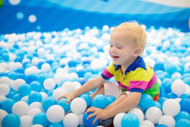 Çocuk top havuzunda oynuyor. Çocuklar için renkli oyuncaklar. Anaokulu ya da anaokulu oyun odası. Kreşteki küçük çocuk oyun parkında. Çocuklar için top havuzu. Aktif anaokulu öğrencisinin doğum günü partisi.