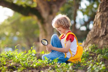 Çocuklar doğayı keşfeder. Çocuklar güneşli yaz parkında yürüyüş yaparlar. İzci kulübü ve açık hava bilimi dersi. Erkek ve kız büyüteçle bitkileri izliyor. Çocuk çevreyi keşfediyor. Genç kaşif macerası.