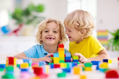 Çocuklar renkli bloklarla oynarlar. Küçük çocuk evde ya da kreşte kule inşa ediyor. Küçük çocuk için eğitici bir oyuncak. Bebek ya da bebek için yaratıcı bir oyun. Anaokulu oyun odasında karışıklık..